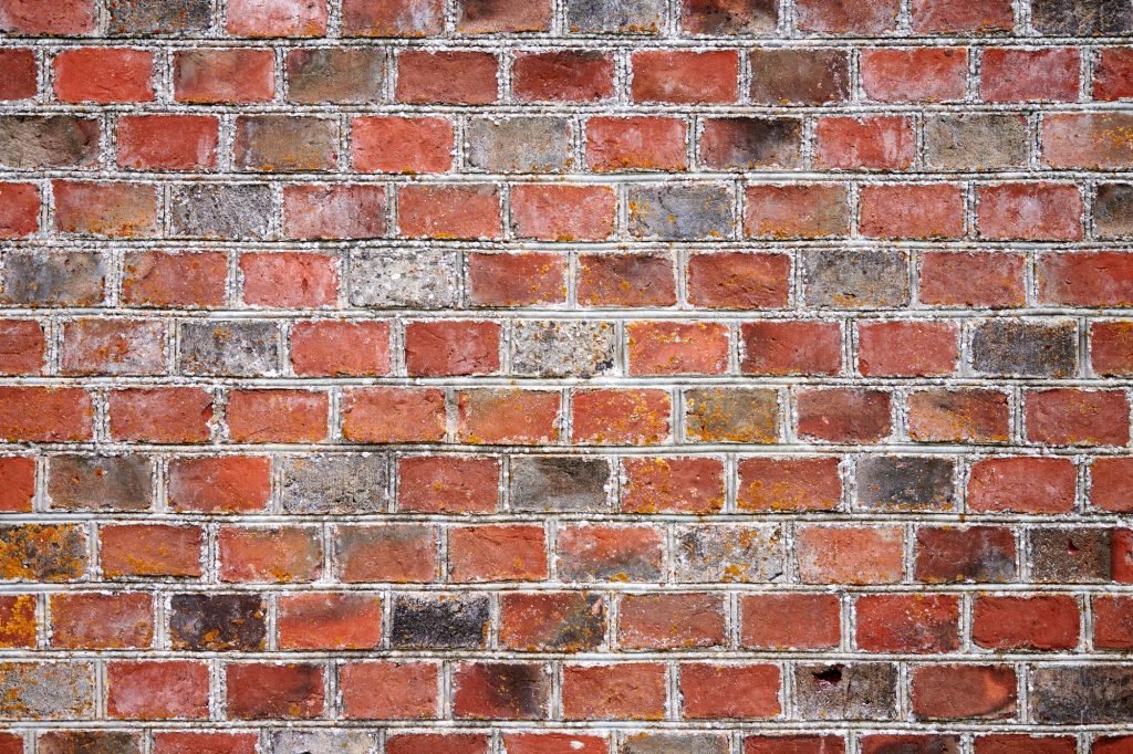 Red brick wall of old house, red brick texture, reliable brickwork masonry with bricklayer